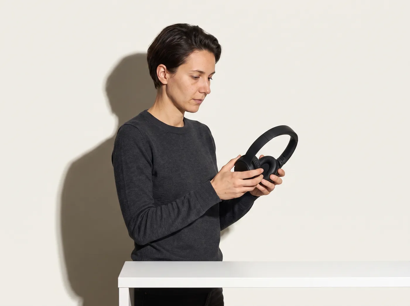 An editor comparing a pair of headphones against its specification